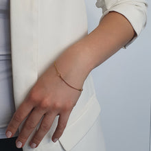 Load image into Gallery viewer, golden-guitar-string-music-bracelet-on-a-light-skin-model