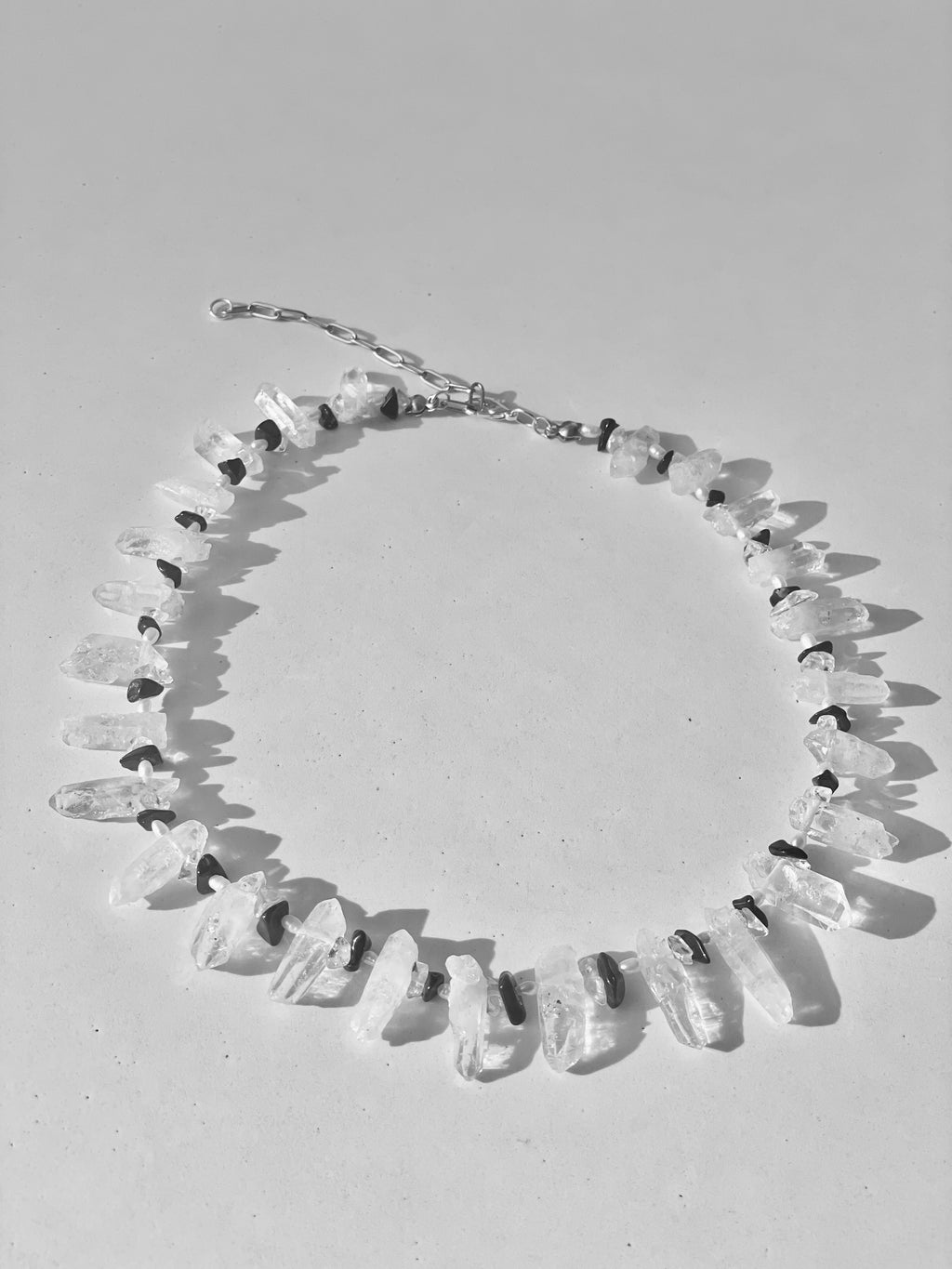 Necklace with clear stone beads on a light gray background
