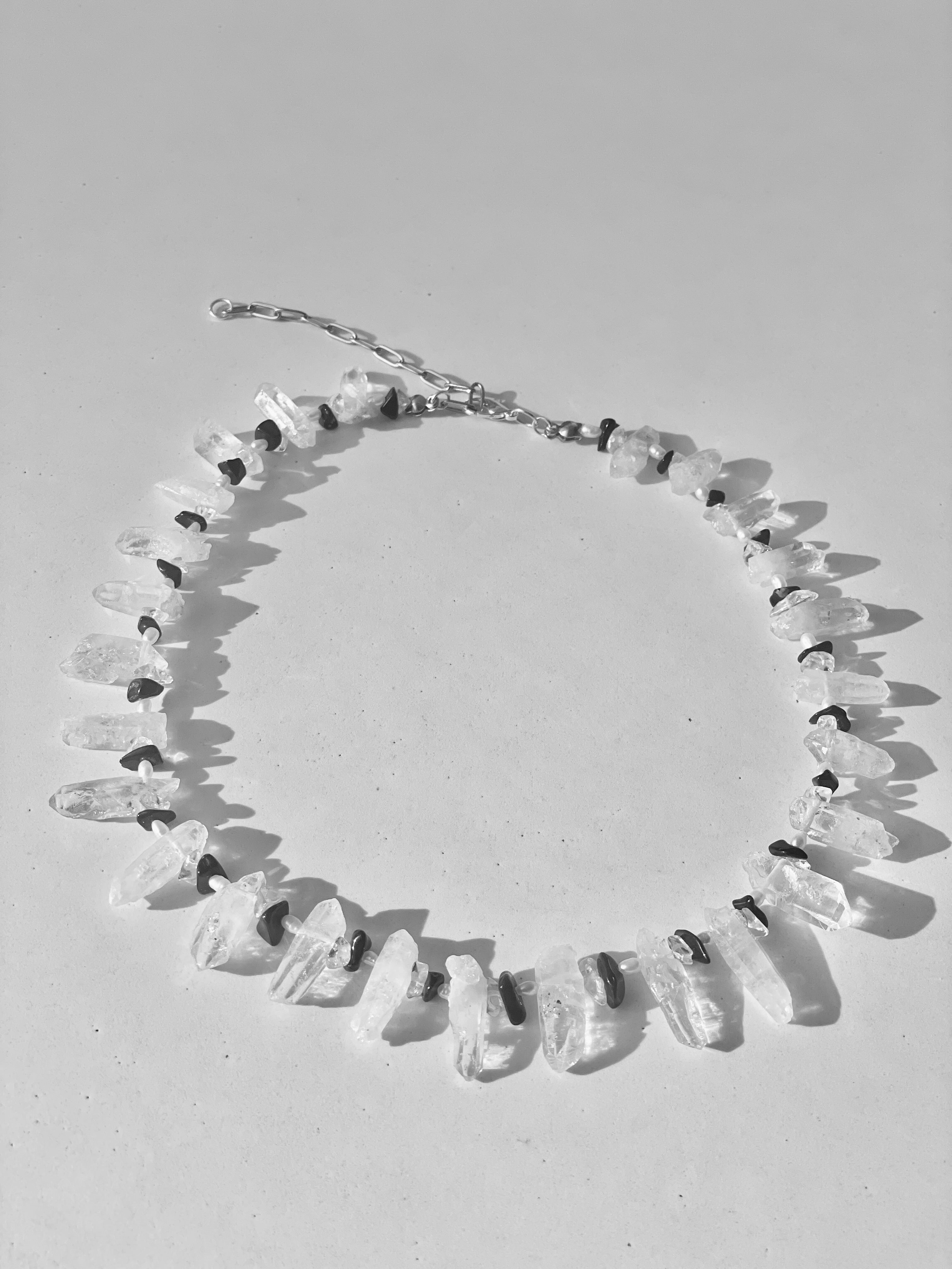 Necklace with clear stone beads on a light gray background