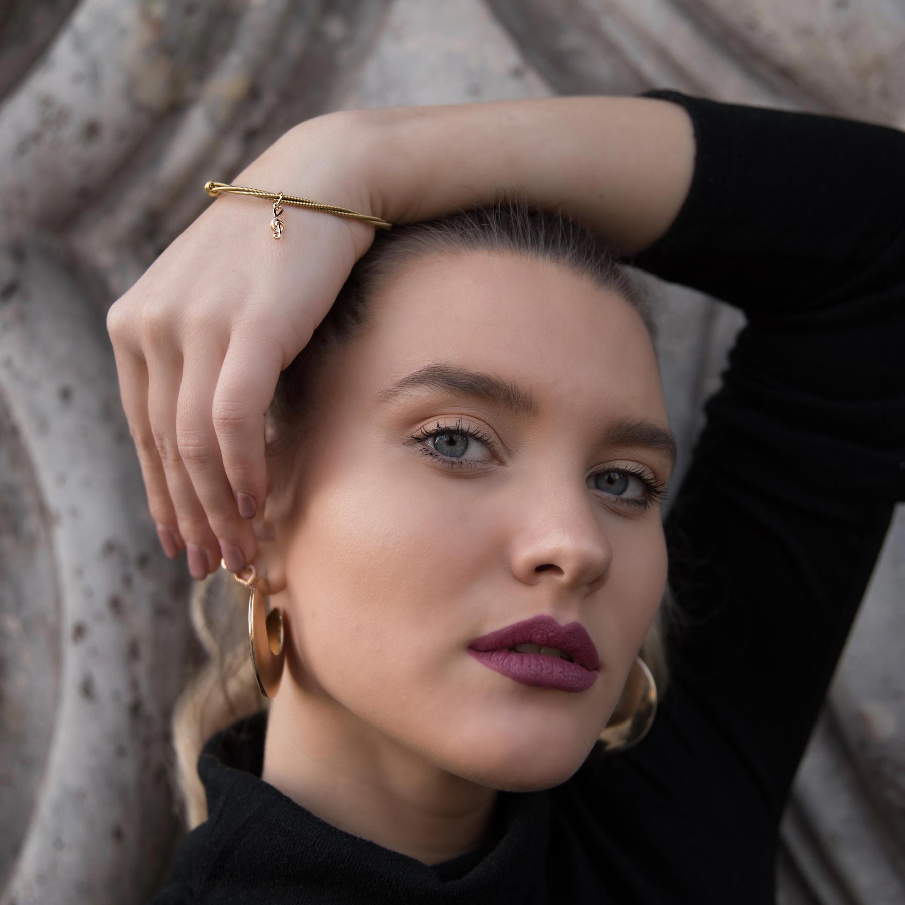 model-wearing-classic-tune-gold-guitar-string-bracelet-by-heartbeat-jewellery-london.jpg
